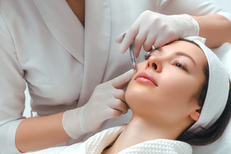 lip shape correction procedure in a cosmetology salon. The specialist makes an injection on the lips of the patient. Lip augmentation.